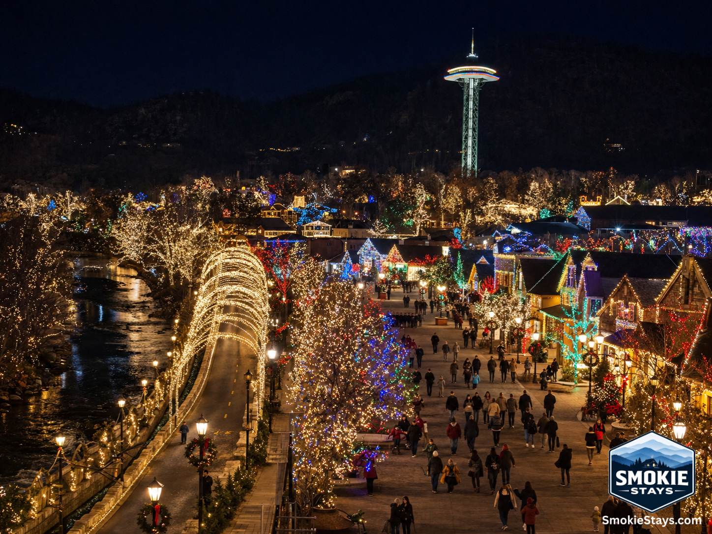 Downtown Gatlinburg glows with over three million LED lights during Winter Magic, with the Space Needle lit above the rooftops and forested Smoky Mountain ridges rising on all sides against the winter night sky.