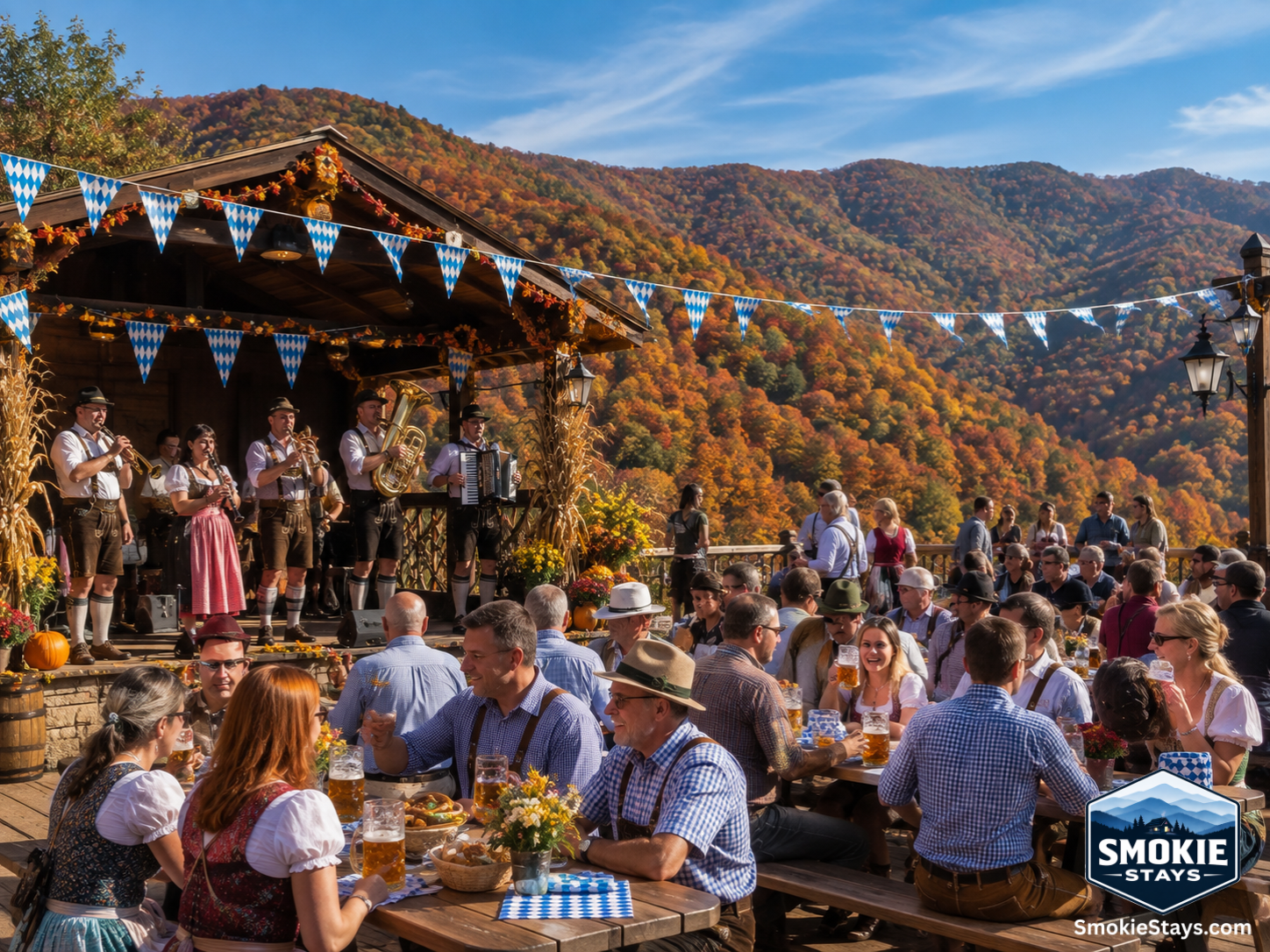 Bavarian performers in traditional costumes play oompah music on an outdoor stage at Oktoberfest at Ober Gatlinburg, with guests holding steins at picnic tables and vibrant fall foliage covering the surrounding Smoky Mountain ridgelines.