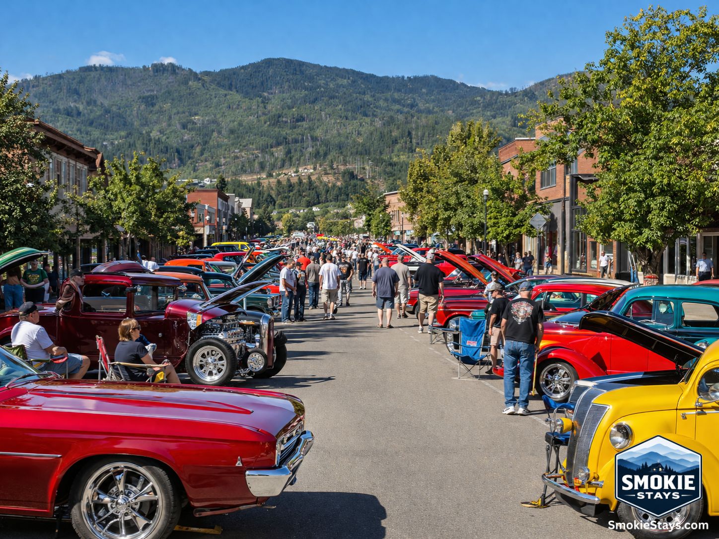 Hundreds of classic American muscle cars, hot rods, and custom builds line the Pigeon Forge Parkway during the Spring Rod Run, with owners in lawn chairs beside their vehicles and forested mountain ridgelines in the background.